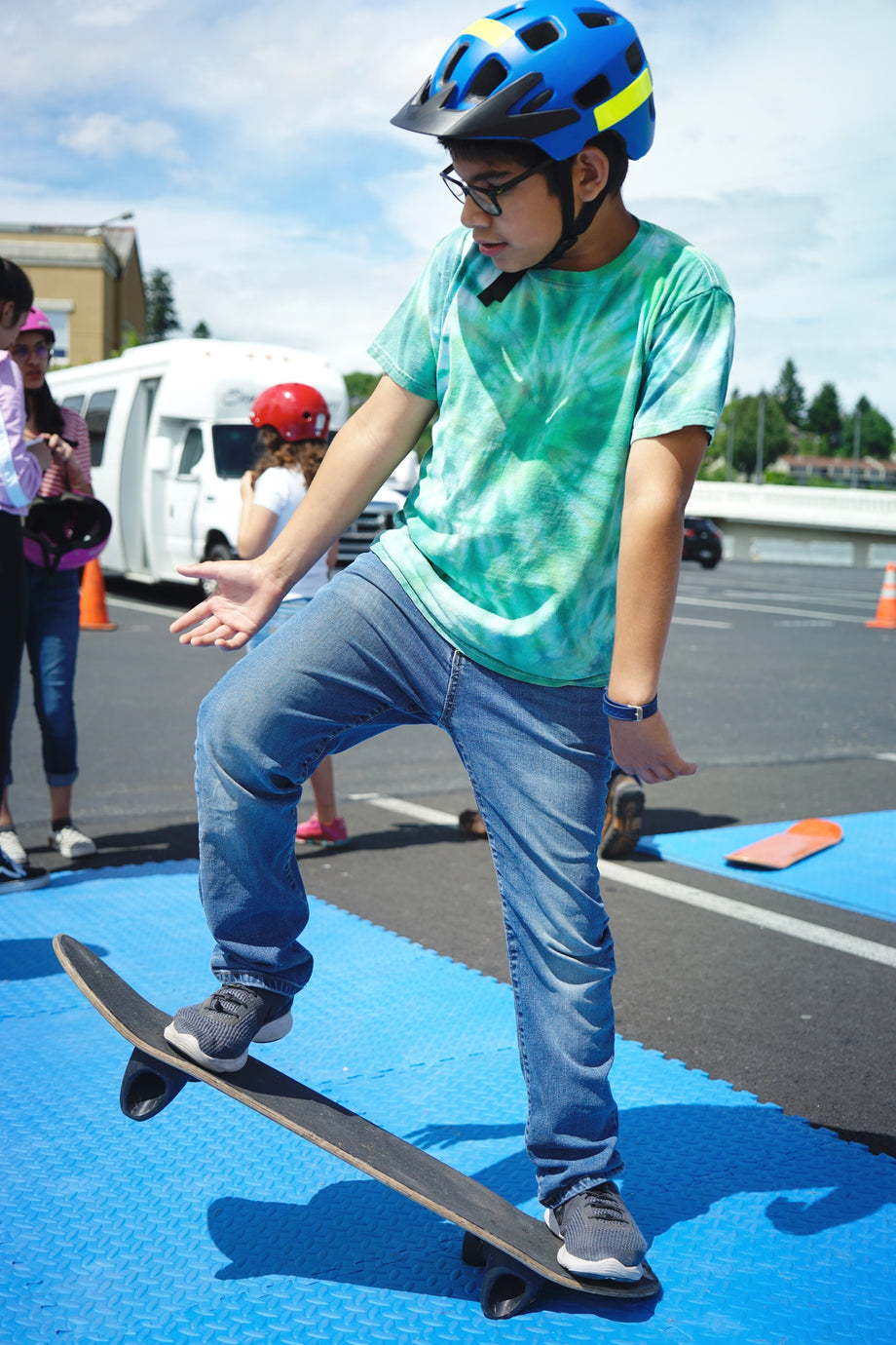 A young skater practicing balance and control on a skateboard at a USSEA event